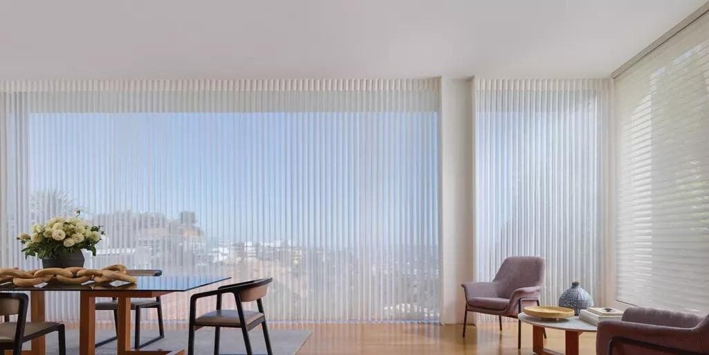 Airy Hunter Douglas Luminette sheer vertical shades with an ocean view, controlled by PowerView motorization.