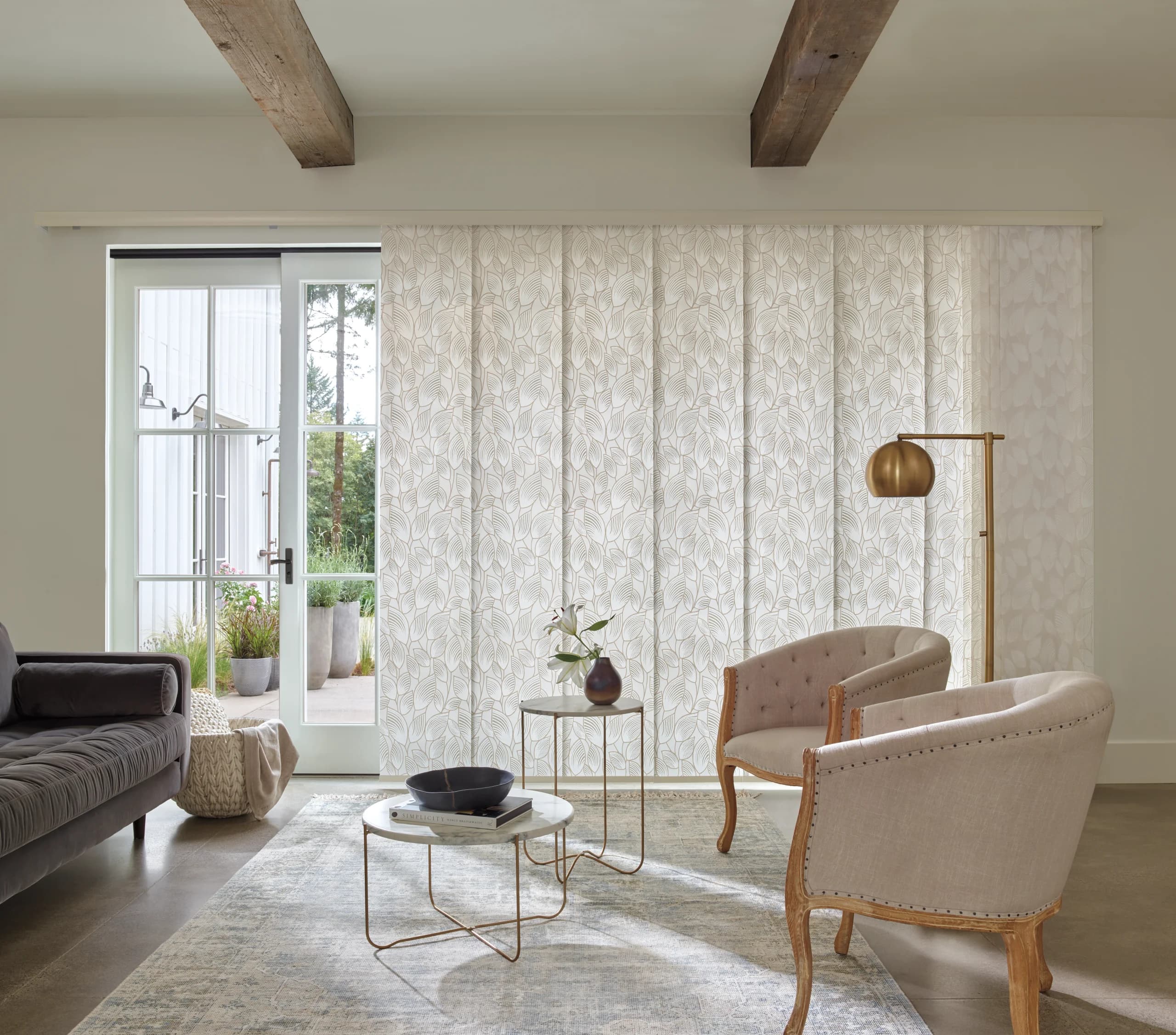 Sheer vertical panels on a wide sliding glass door opening to a green backyard.