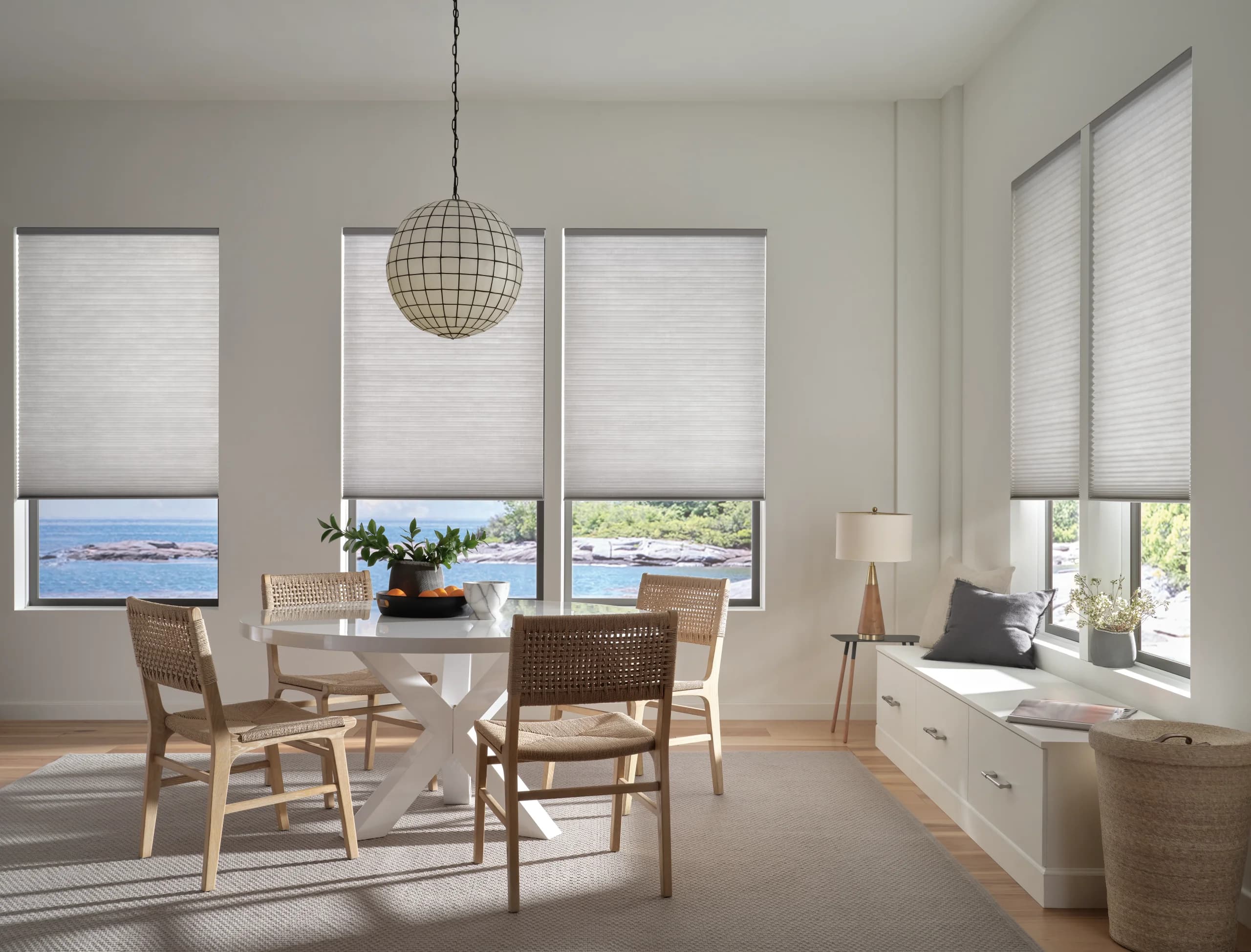 Hunter Douglas Applause® Honeycomb Shades lowered across a dining room window in a soft grey fabric.
