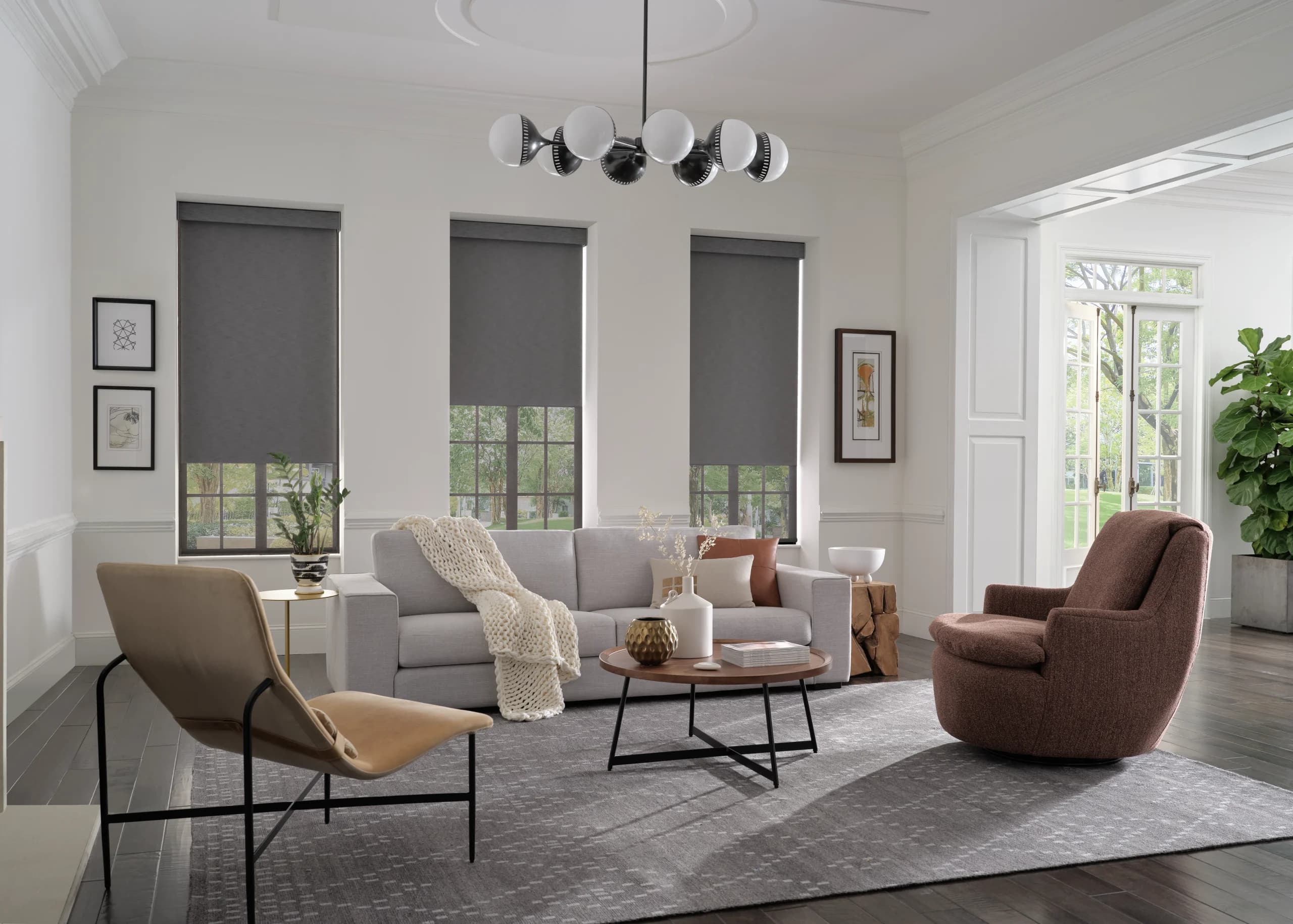 Designer Roller Shades in a soft neutral fabric across a bright living-room window wall.