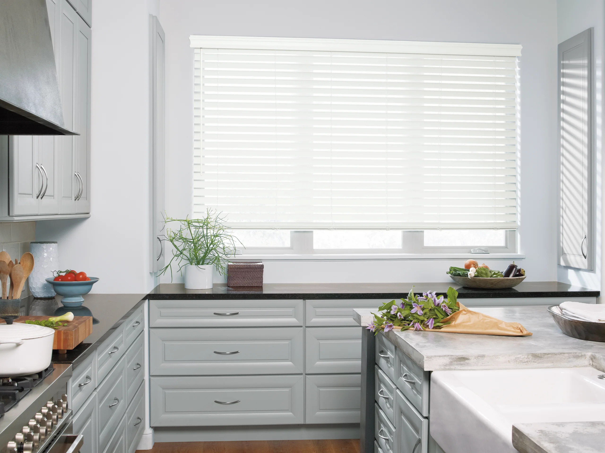 Hunter Douglas EverWood® Alternative Wood Blinds over a kitchen window, tilted open to the daylight.