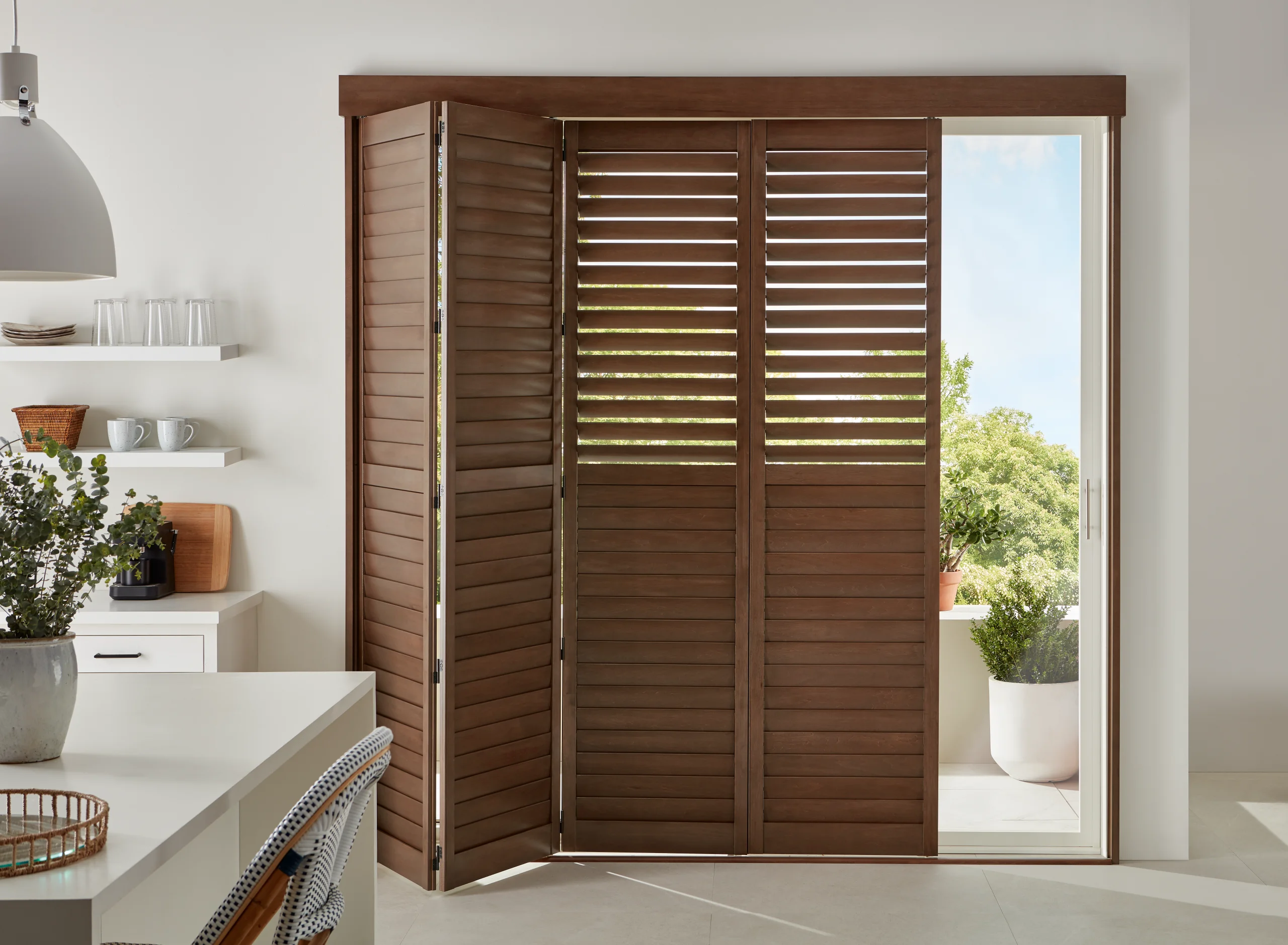 Hunter Douglas Heritance® Hardwood Shutters on a bi-fold track across a kitchen door.