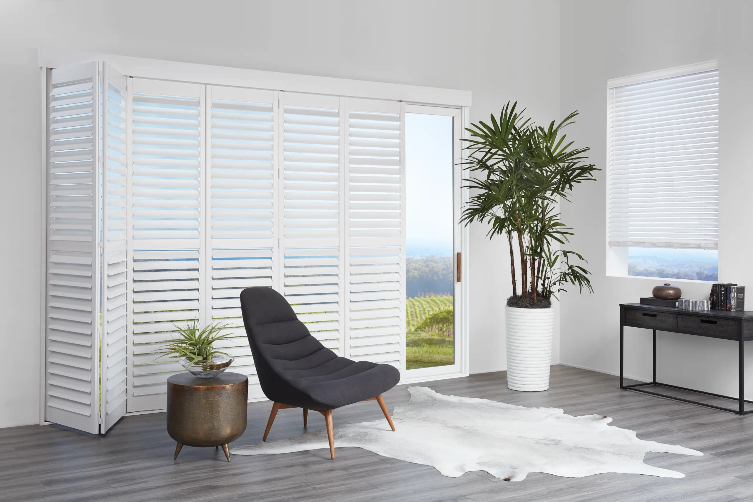 Hunter Douglas NewStyle® Hybrid Shutters on a bi-fold track across a den opening.