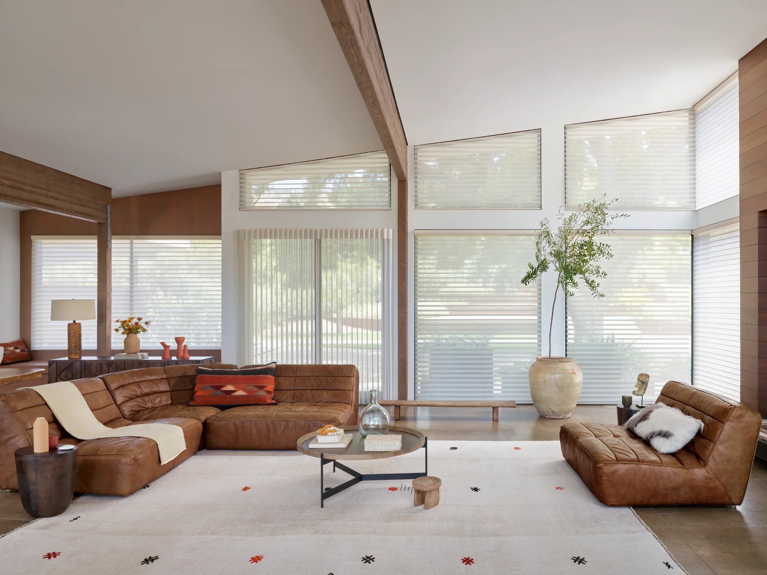 Hunter Douglas Luminette® Privacy Sheers glowing behind a window bench in a living room.