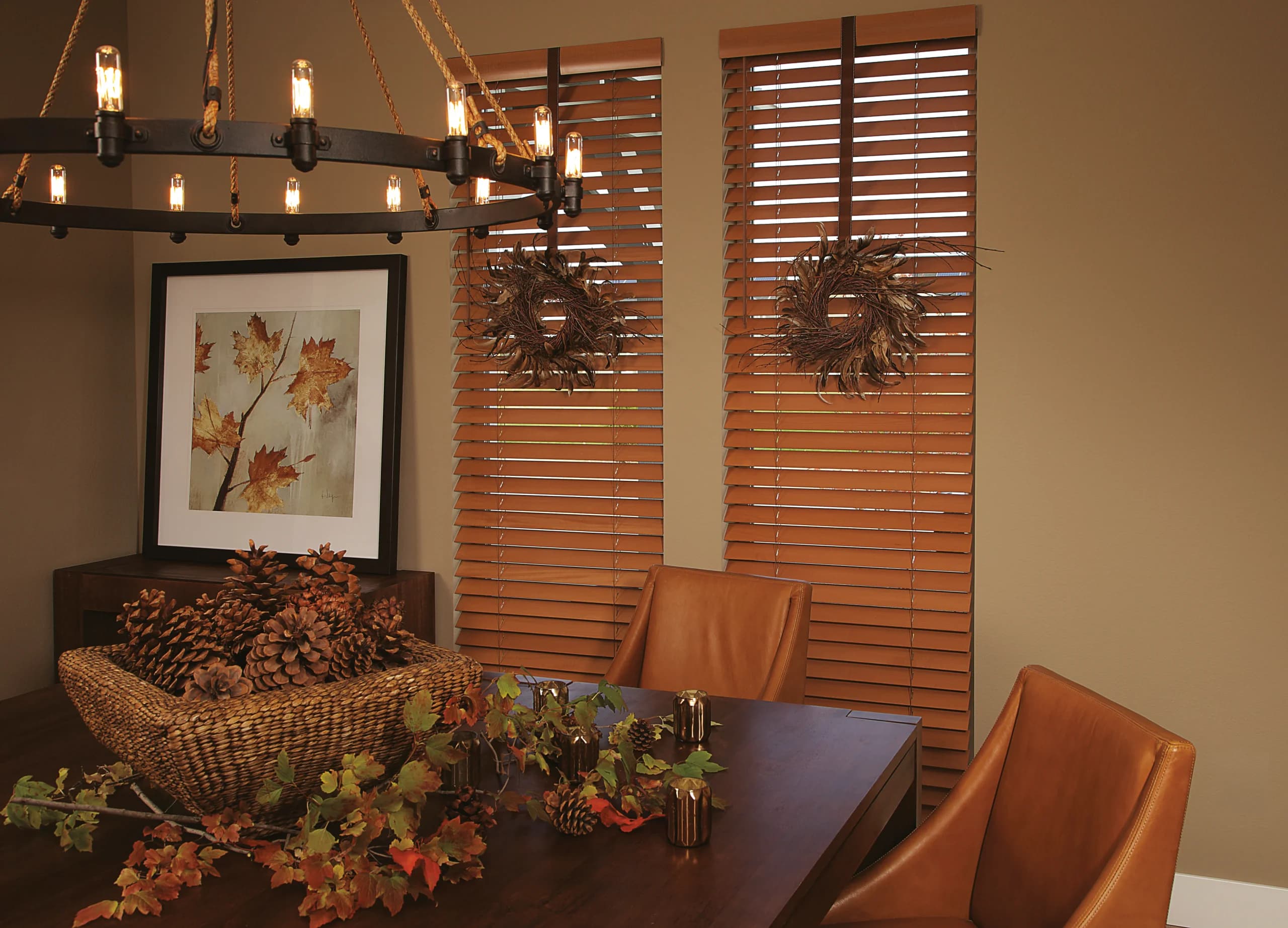 Hunter Douglas Parkland® Wood Blinds in a warm honey stain with decorative tapes on two dining room windows.