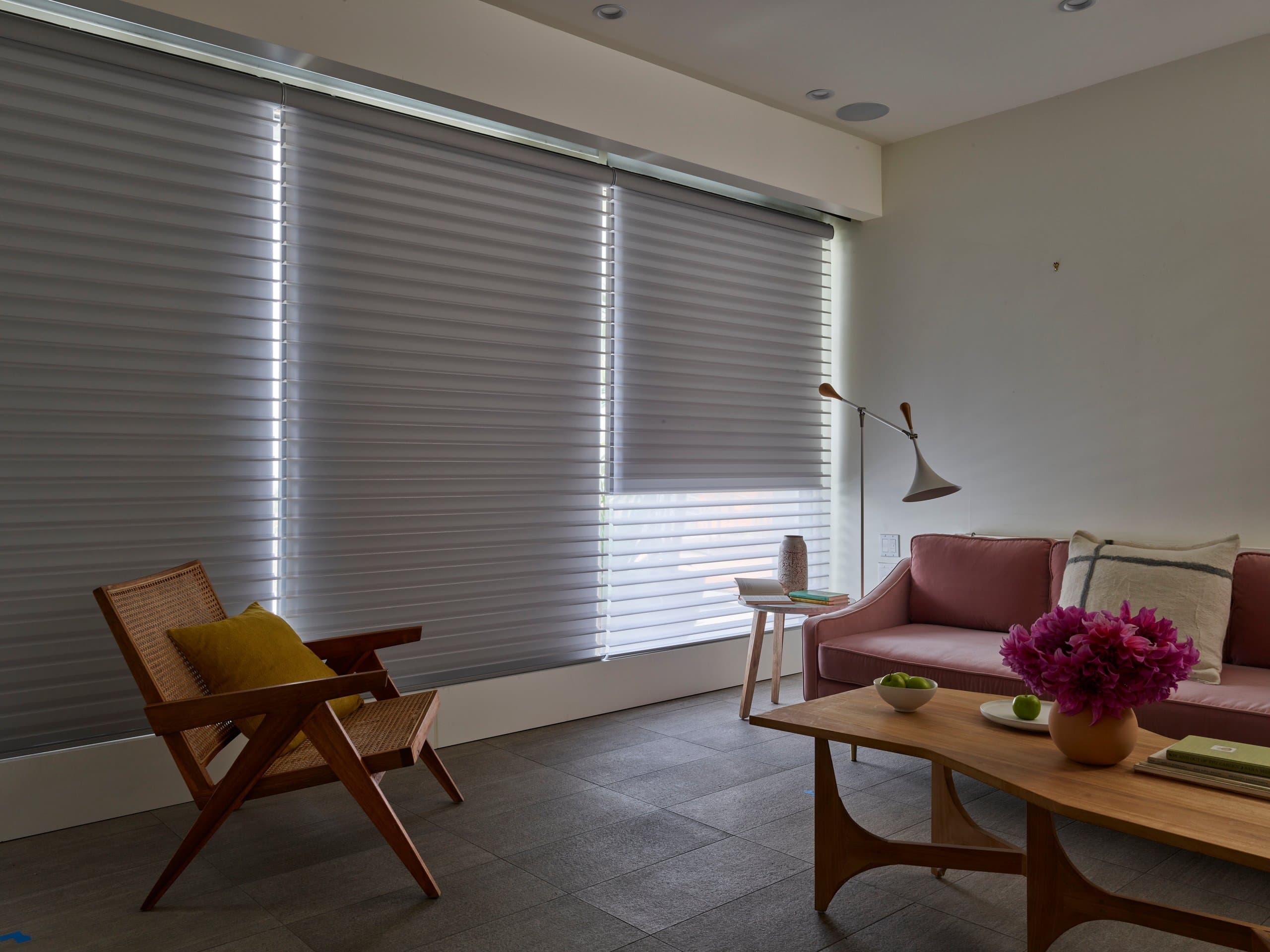 Hunter Douglas Silhouette® Window Shadings in soft grey lowered across a wide living room window, one shade partly raised.