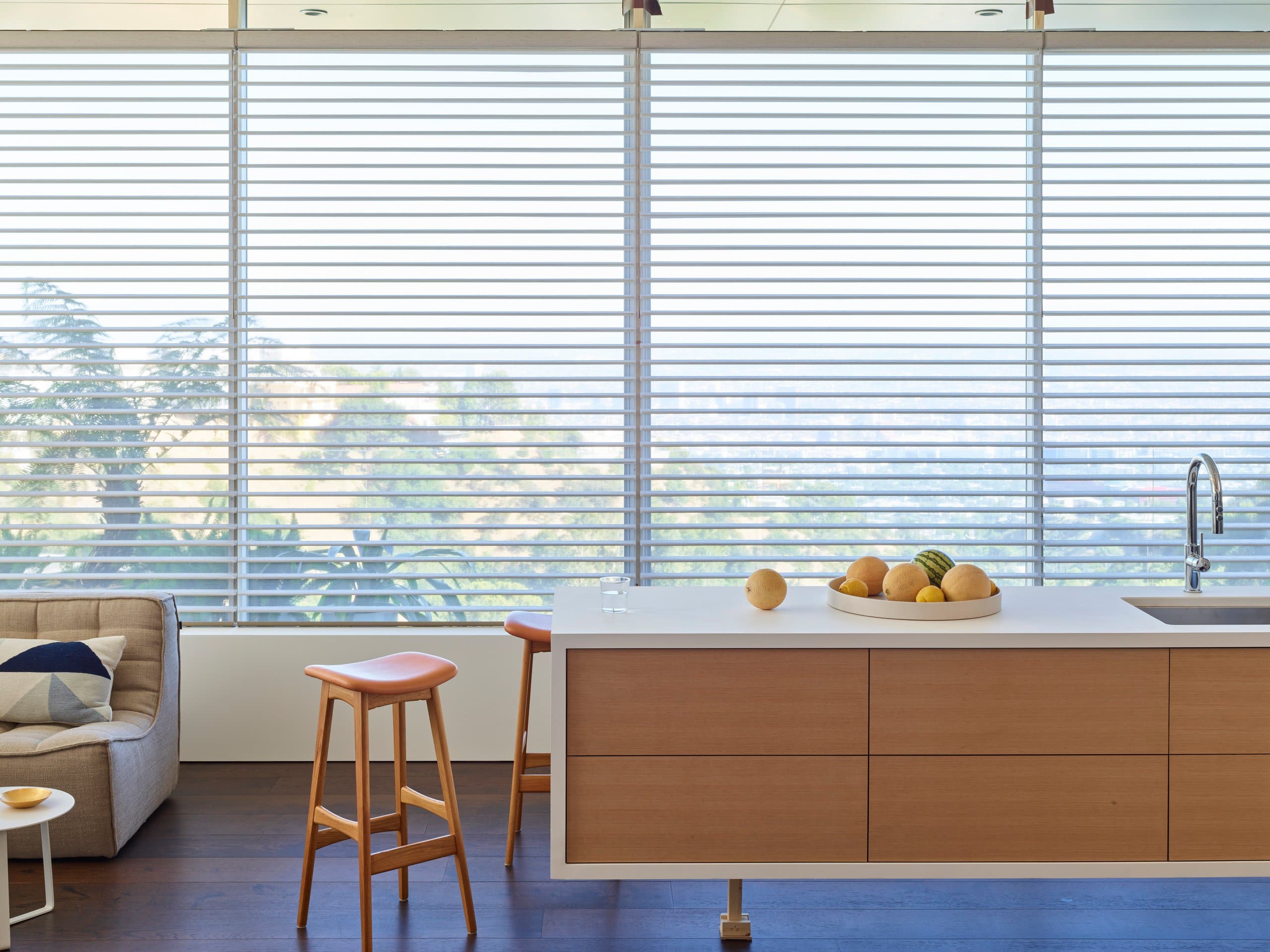 Hunter Douglas Silhouette® Window Shadings filling a window wall behind the island of an open kitchen and sitting area.