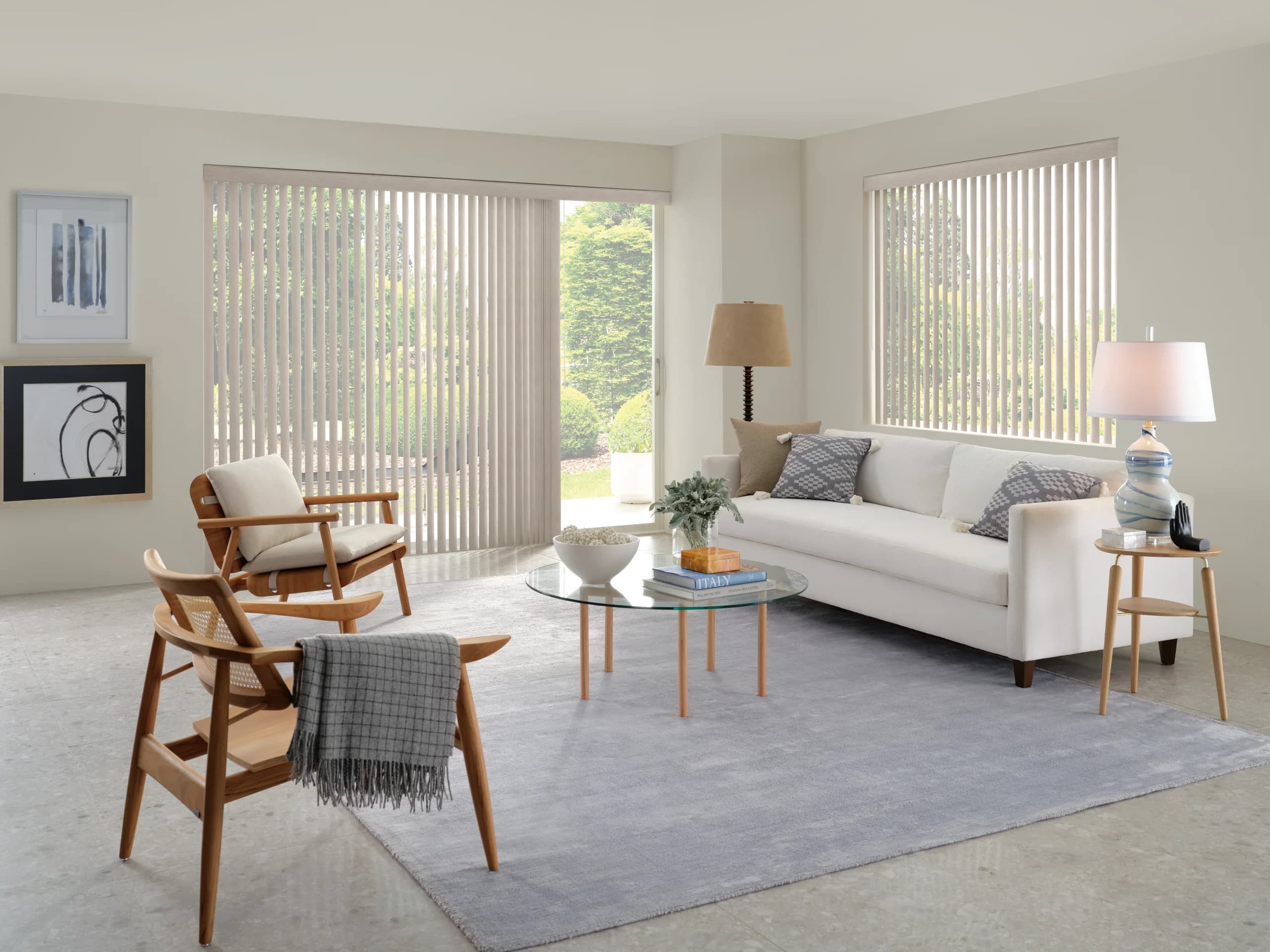 Hunter Douglas Somner® Custom Vertical Blinds drawn across a sliding glass door and a side window in a bright living room.