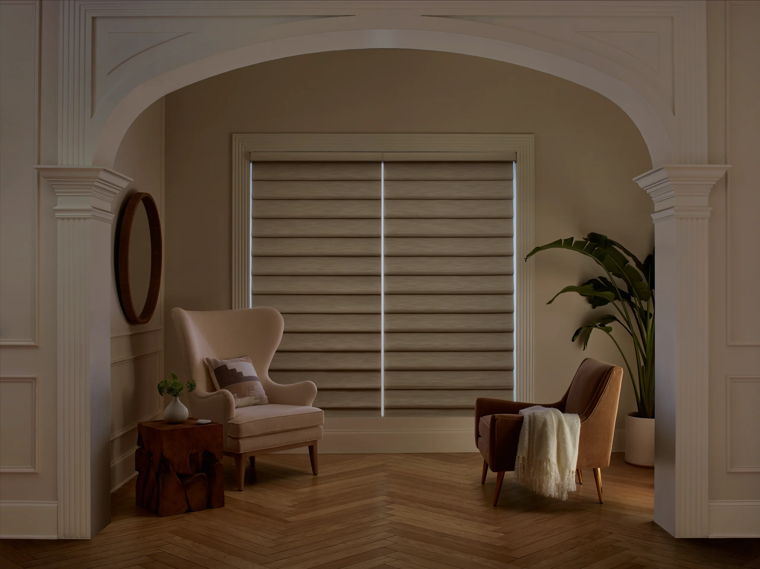 Hunter Douglas Vignette® Modern Roman Shades in a room-darkening fabric closed across a sitting area window.
