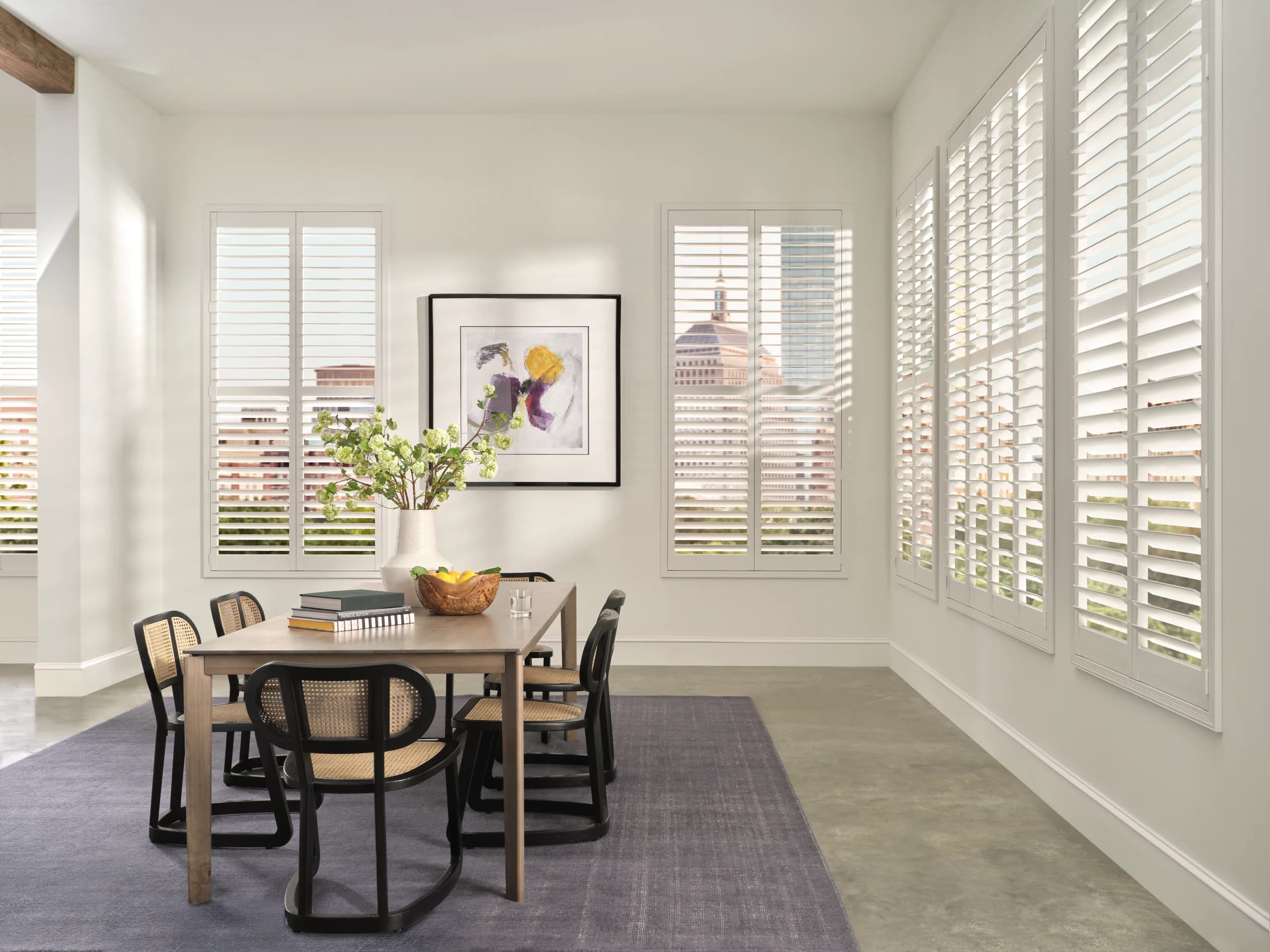 Plantation shutters framing French doors with a New England ocean view.