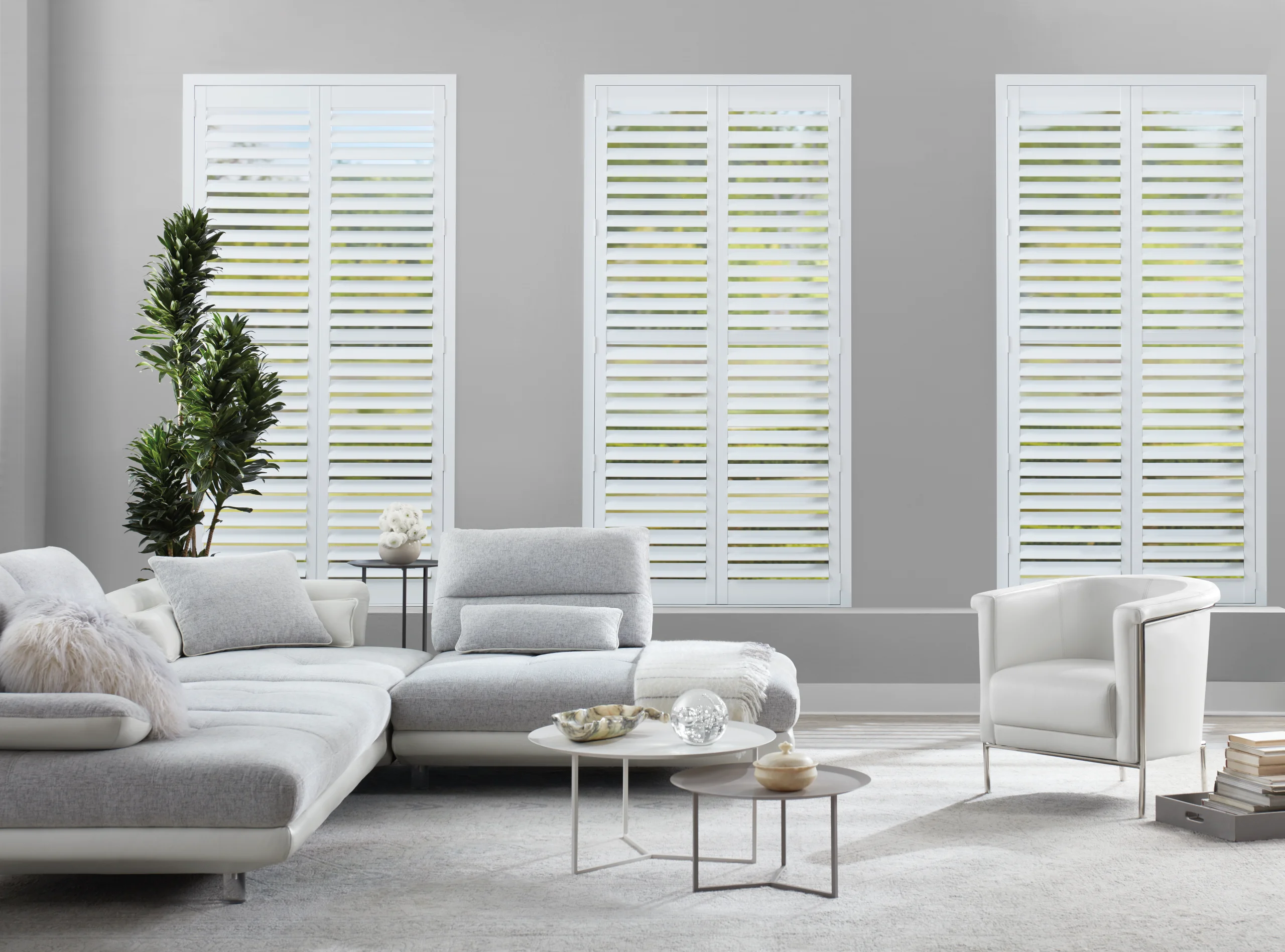 Hunter Douglas NewStyle® Hybrid Shutters on hinged panels across a living room window.