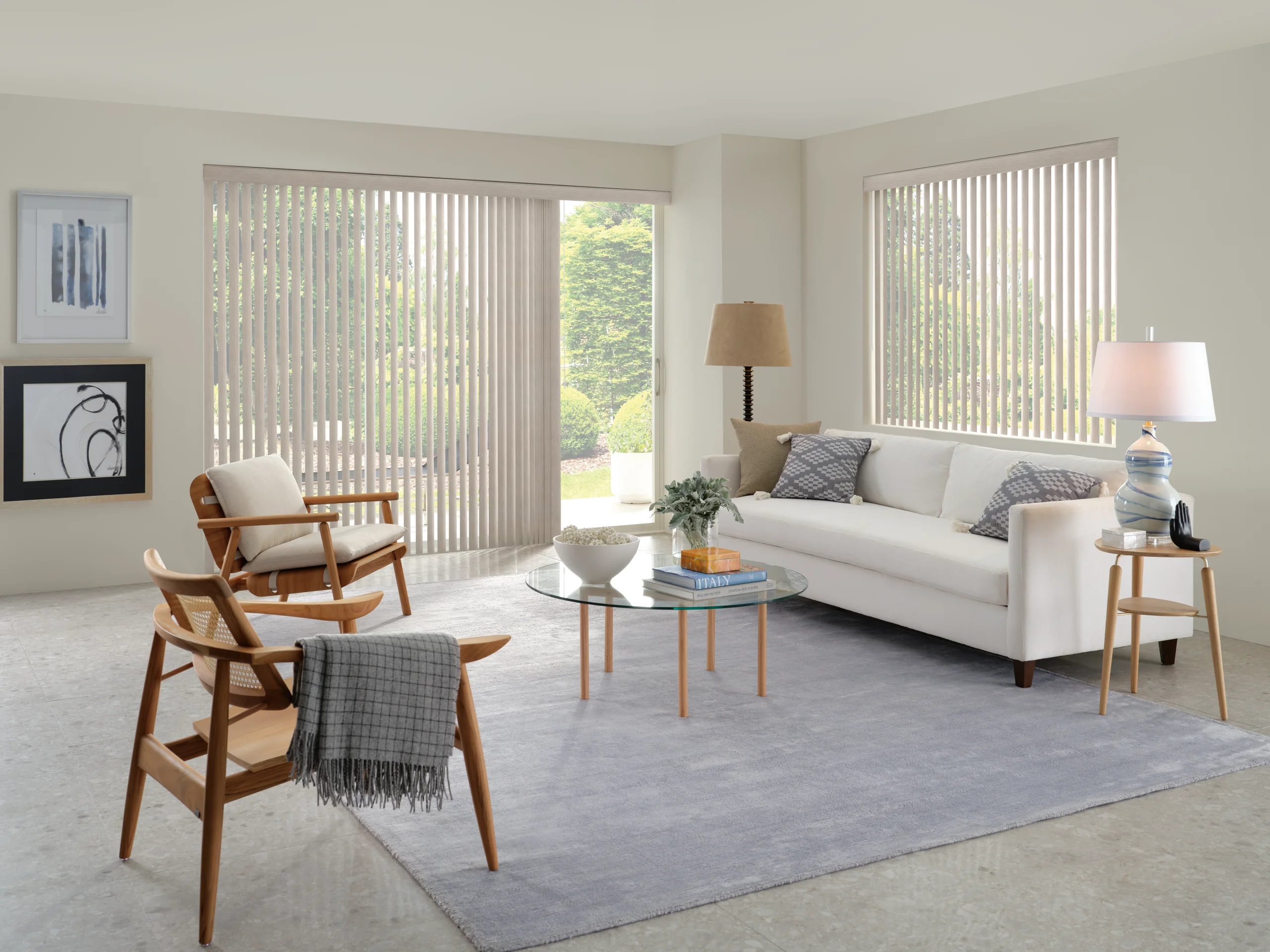 Hunter Douglas Somner® Custom Vertical Blinds drawn across a sliding glass door and a side window in a bright living room.
