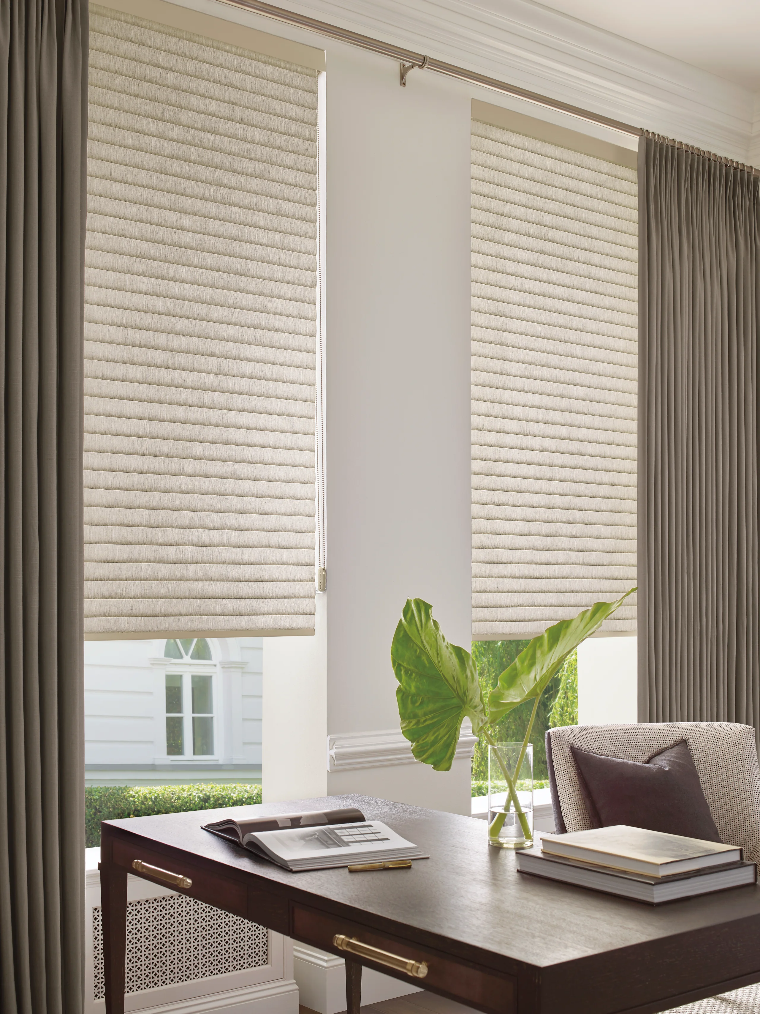 Hunter Douglas Sonnette® Cellular Roller Shades at an office window, layered behind drapery panels.