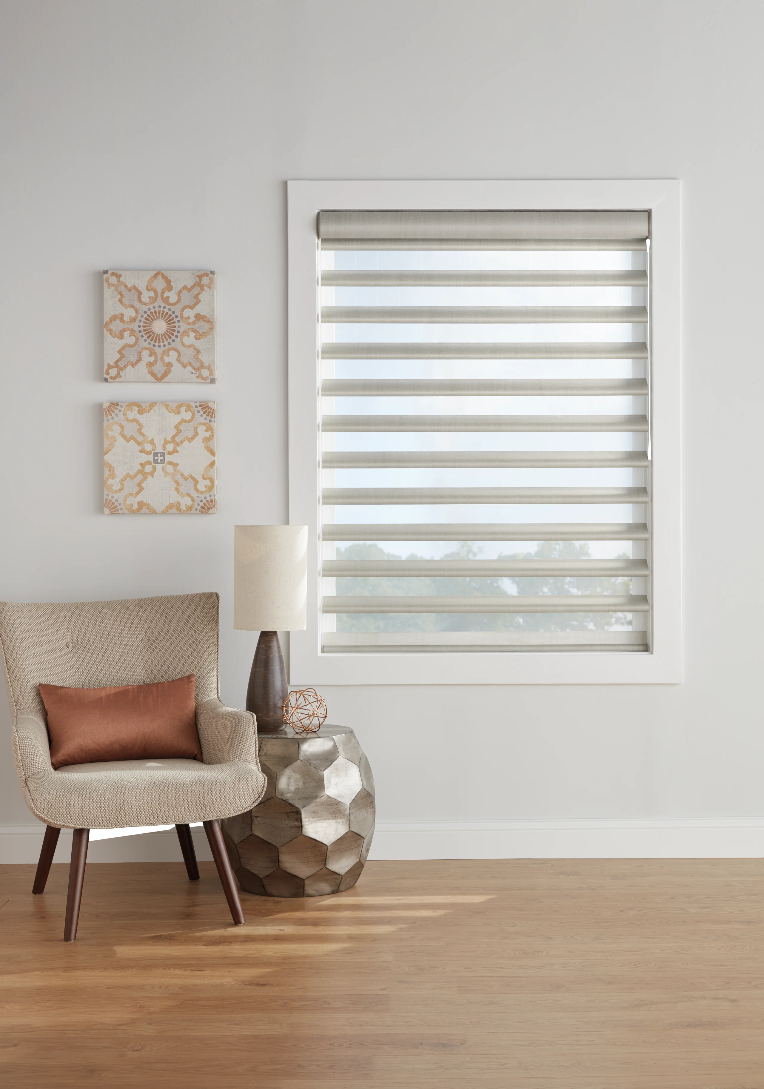 Hands holding fabric swatches up to a sunlit window to judge their color in the home's own light.
